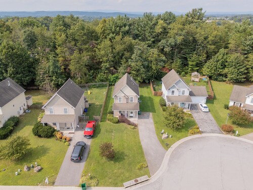 Spacious family home with multiple bedrooms, full kitchen, porch, and quaint backyard.