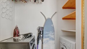 A laundry area with a washing machine, dryer, and an ironing board.