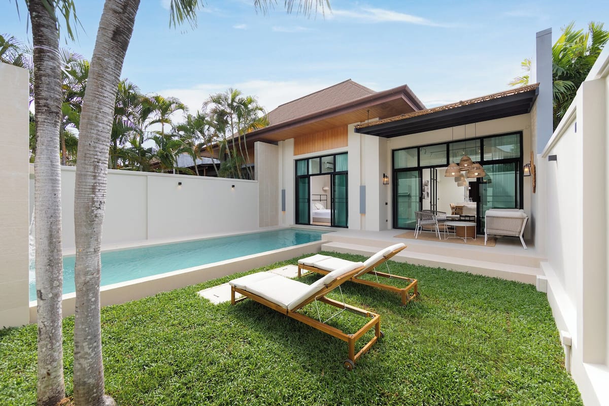 A modern house with a swimming pool, a covered patio, and a dining area.