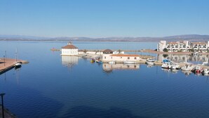 A marina with boats docked, a small building with a red roof, and a clear blue sky. - Air-conditioned apartment with splendid panoramic view - COUDALERE pedestrian village (barcares)