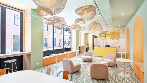A modern interior with round tables, cushioned seating, and unique hanging light fixtures. - Boavista 83 Hostel Lisbon (Lisbon)