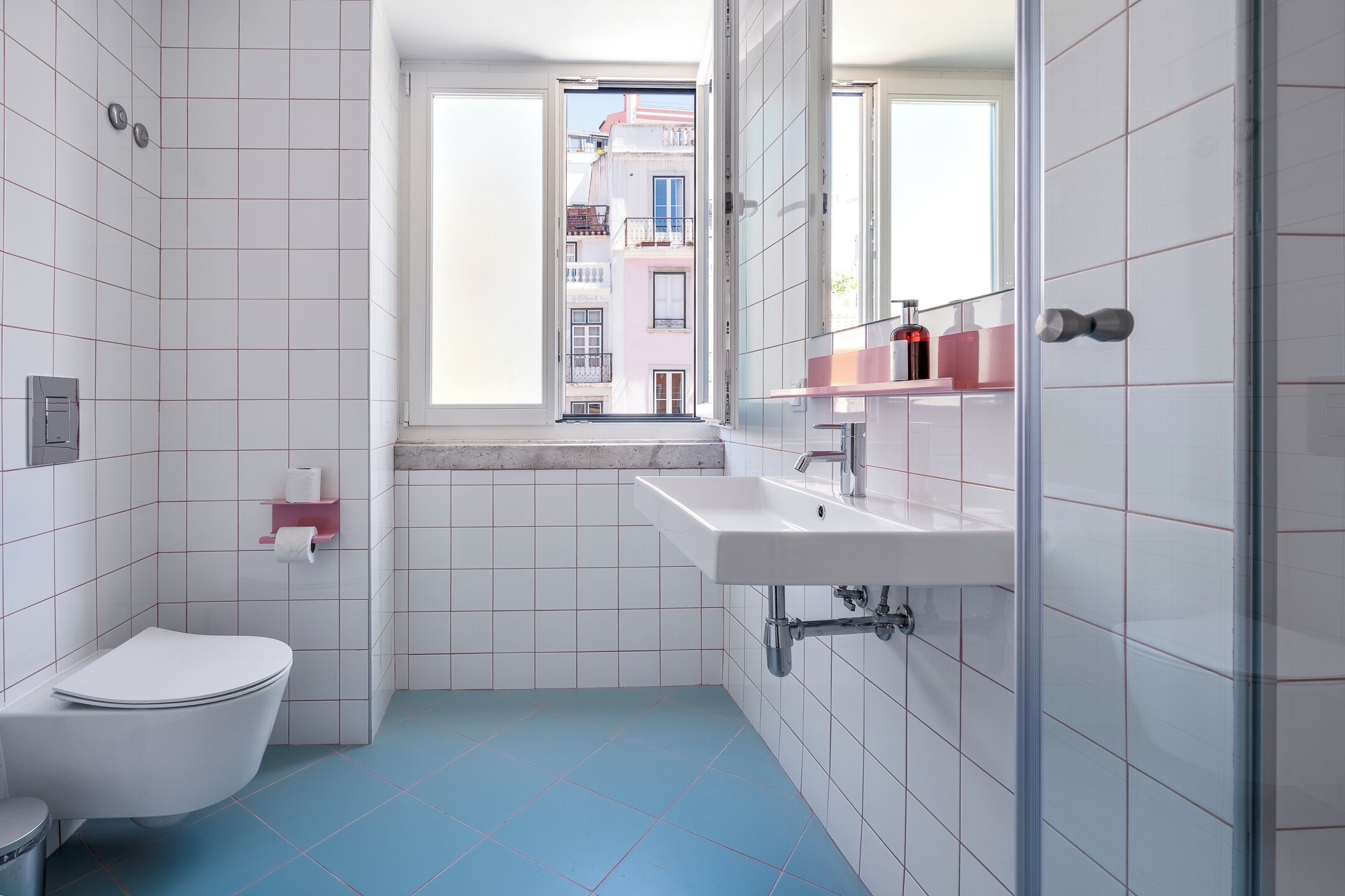 Une salle de bain moderne avec des toilettes, un lavabo et une fenêtre.