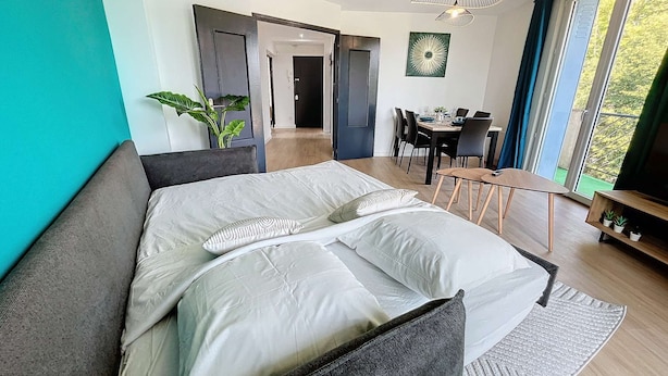 Une chambre moderne dotée d’un grand lit, d’un coin repas et offrant une vue sur l’extérieur.
