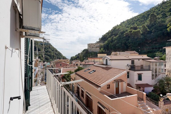 A residential area with buildings, a balcony, and a view of a hillside.
