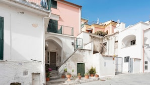 A narrow street with buildings, a green door, and potted plants. - Apartment 'Ce Tour - Casa Cetara Centro 1' with Private Terrace, Wi-Fi and Air Conditioning (Cetara)