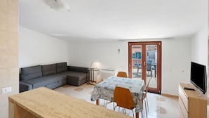 A compact living space with a kitchenette, a dining area, a sofa, and a television. - Apartment 'Ce Tour - Casa Cetara Centro 1' with Private Terrace, Wi-Fi and Air Conditioning (Cetara)