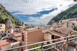 Un pueblo costero con edificios de tejados terracota, balcones y una vista despejada del mar.