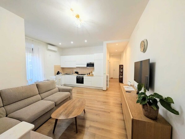 A modern apartment with a living room, kitchenette, and a dining area. - Family-friendly apartment. 20 min walk to Vatican and shoping areas. (Roma)