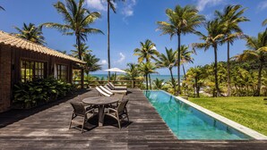 A wooden deck with a pool, lounge chairs, and a view of the ocean. - Fazenda Jeribucaçu (Itacaré)