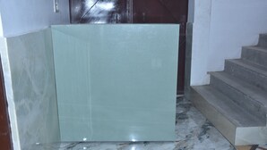 Un suelo de mármol con un panel de vidrio y una escalera.