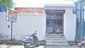 Un edificio con un letrero y una moto estacionada en la entrada.