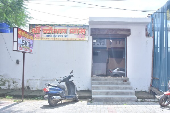 A building with a signboard and a scooter parked in front. - SKD  (Kanpur)