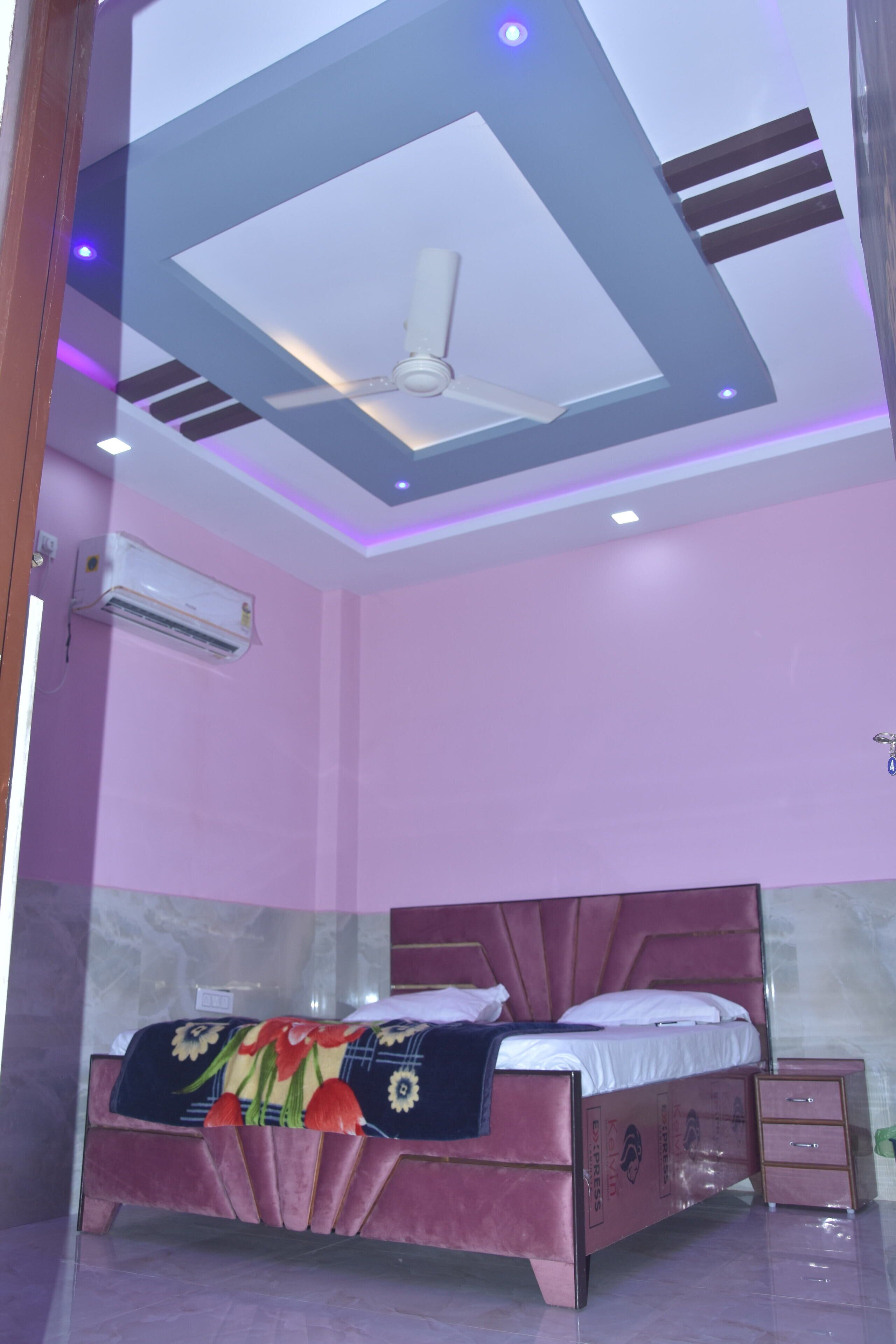 Une chambre à coucher avec un lit, un ventilateur de plafond et un appareil de climatisation.