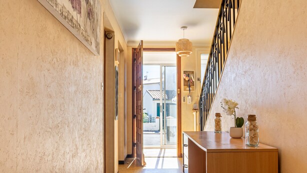 A hallway with a wooden cabinet, a door leading to a balcony, and a staircase with a railing. - Waterfront Apartment with Garden (Limoux)