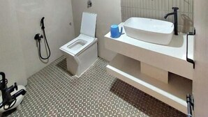 Casa de banho moderna com sanita, bidé, lavatório e chuveiro.