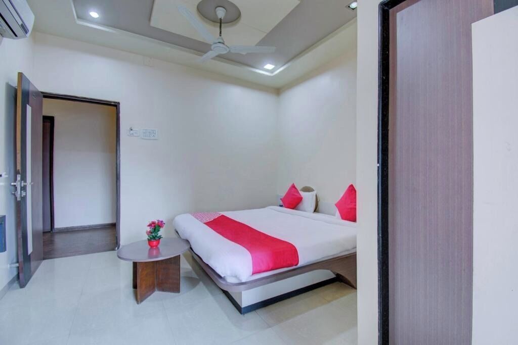 A hotel room with a bed, bedside table, and a ceiling fan.