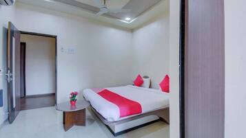A hotel room with a bed, bedside table, and a ceiling fan.