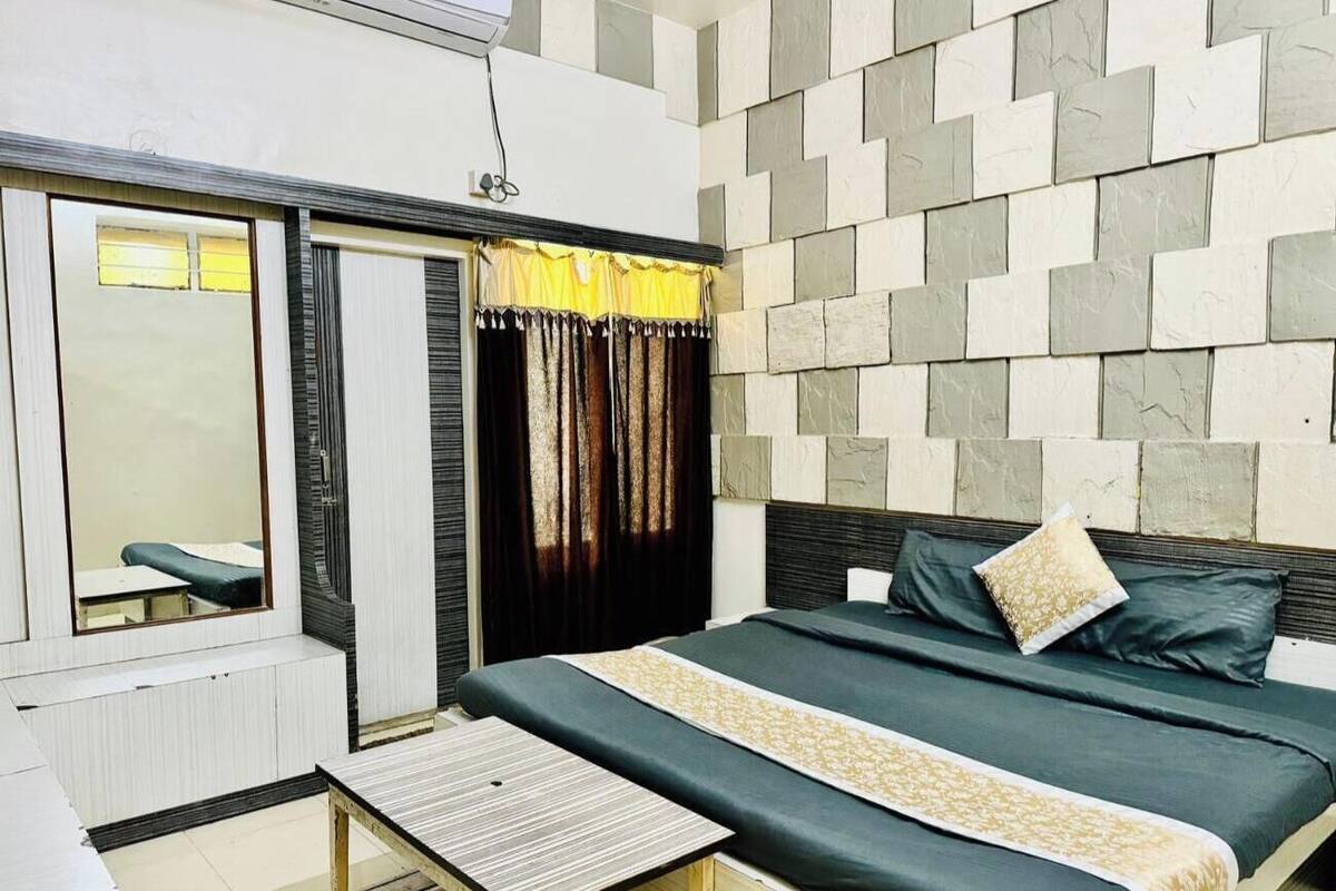 Ein Schlafzimmer mit Bett, Nachttisch, Fenster mit Vorhängen und Wand mit Musterdesign.