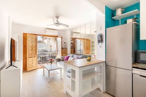 A modern kitchen with a refrigerator, microwave, and a dining area with a table and chairs.