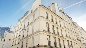 A multi-story building with a classic architectural style, featuring symmetrical windows and balconies. - Lovely Studio With AC - Center of Paris (Paris)