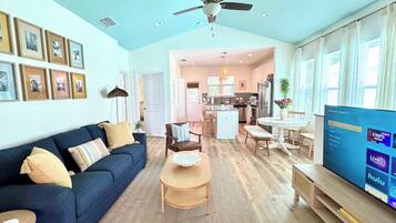 A spacious living area with a sofa, coffee table, and TV.