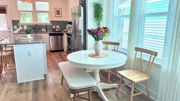 Une cuisine moderne avec un coin repas, comprenant une table ronde, des chaises et un banc.