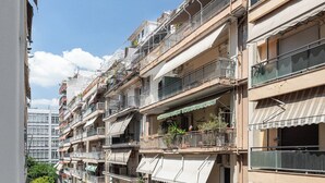 Een meerhoog gebouw met balkons, terras en een zichtbaar restaurantbord.