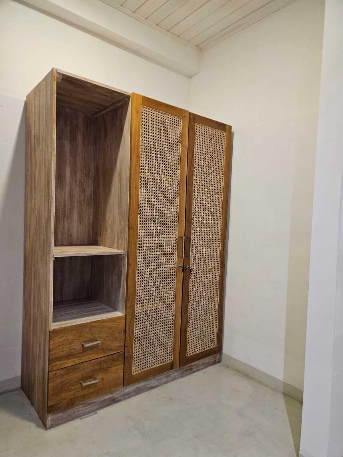 Ein Holzkleiderschrank mit zwei Türen und einer Ablage, mit eingewebtem Panel-Design.