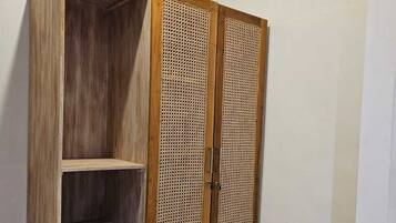 Ein Holzkleiderschrank mit zwei Türen und einer Ablage, mit eingewebtem Panel-Design.