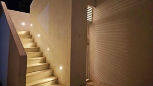 Eine modern gestaltete Treppe führt zu einer Tür mit einer strukturierten Wand.