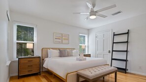 A bedroom with a bed, bedside tables, a bench, a ceiling fan, and a ladder. - 2 Grills + Firepit Deck | Pets Welcome | Close to Barr & Walnut Trails (Austin)