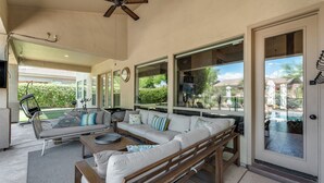 A spacious patio with a sofa, chairs, and a dining table.