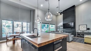 A modern kitchen with a central island, large windows, and a built-in oven.