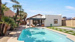 A modern house with a swimming pool, a patio, and a garden with palm trees. - 3BR w/ FREE Pool Heat | Hatcher Hideaway (Glendale)
