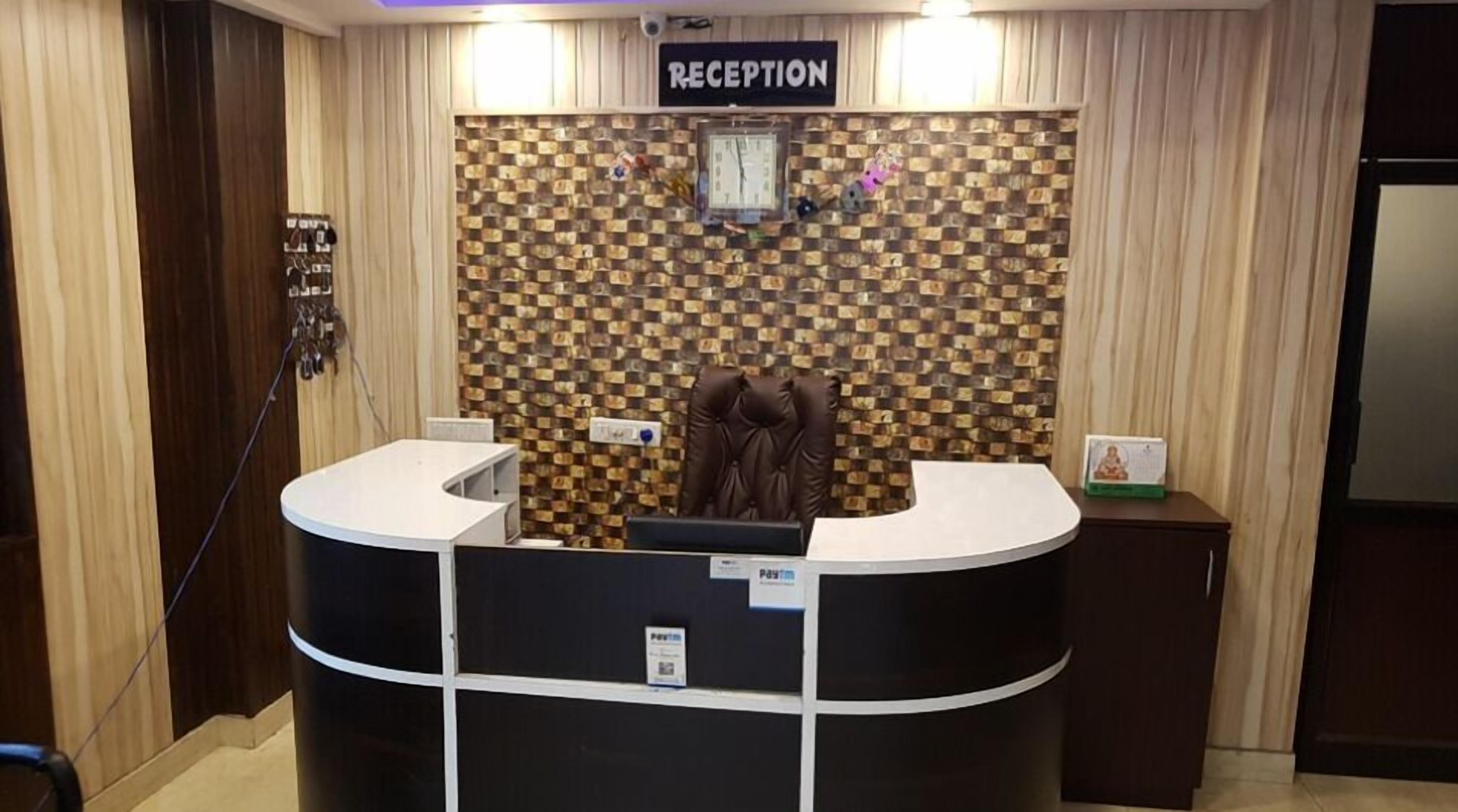 A reception area with a checkered wall, a reception desk, and a clock.
