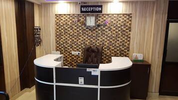 A reception area with a checkered wall, a reception desk, and a clock.