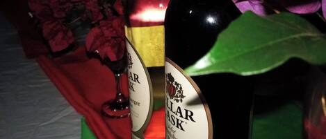 Two bottles of wine on a table with a red cloth.