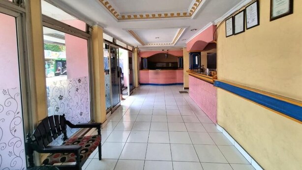 Un pasillo con un banco, una recepción y certificados enmarcados en la pared.