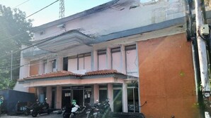 Un edificio de dos plantas con tejado de baldosas y fachada de ladrillo.