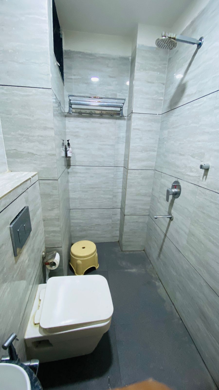 Um banheiro pequeno e compacto com vaso sanitário, pia e chuveiro.