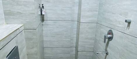 A small, compact bathroom with a toilet, a sink, and a shower.