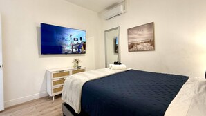A bedroom with a bed, a dresser, a TV, and artwork on the walls. - Private 1 bedroom luxury mother-in-law suite close proximity to Midtown Tampa (Tampa)