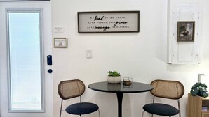A dining area with a round table, two chairs, a framed inspirational quote, a small potted plant, and a picture frame on the wall. - Private 1 bedroom luxury mother-in-law suite close proximity to Midtown Tampa (Tampa)