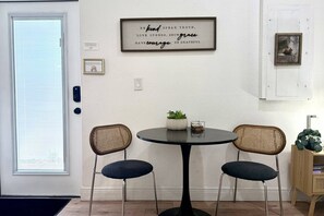 A dining area with a round table, two chairs, a framed inspirational quote, a small potted plant, and a picture frame on the wall. - Private 1 bedroom luxury mother-in-law suite close proximity to Midtown Tampa (Tampa)