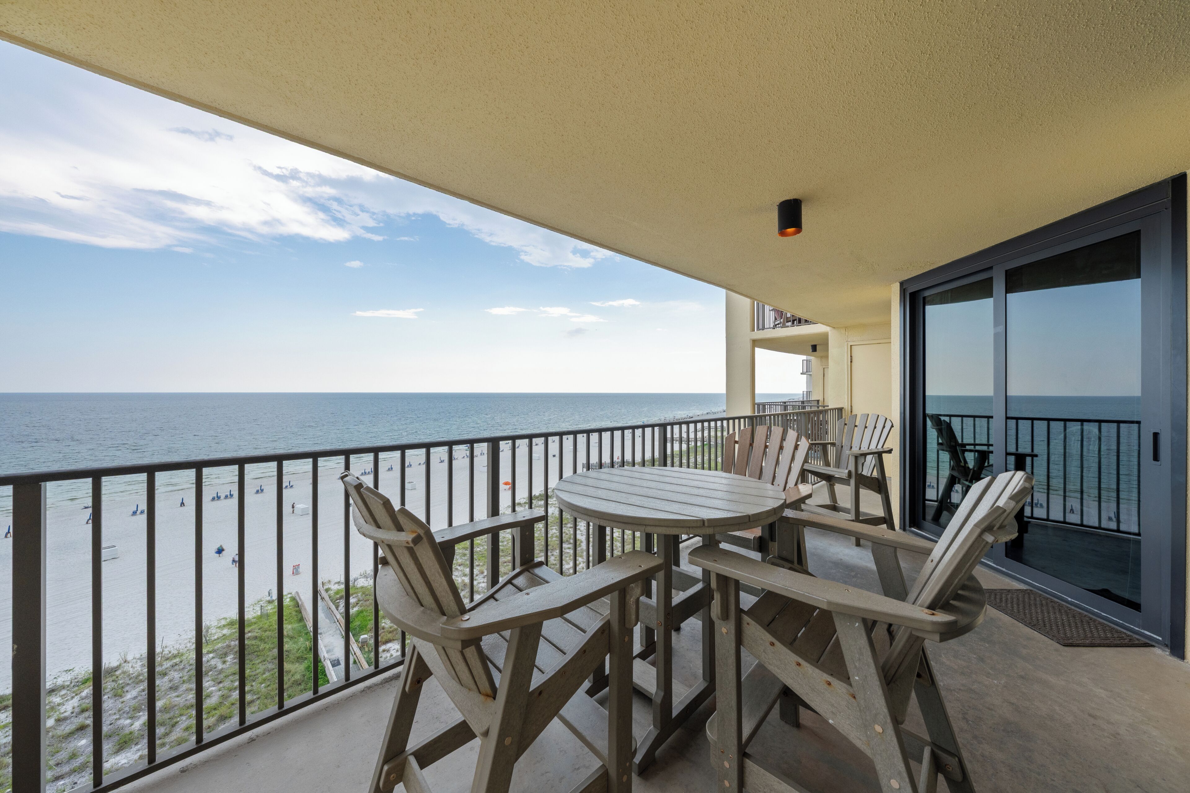 Balcón con mesa y sillas con vista a la playa.