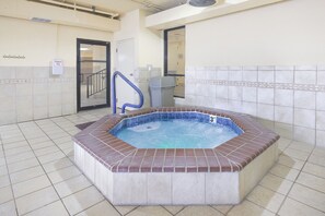 A 3ft hot tub in a room with tiled flooring, a door labeled "Emergency Exit," and a trash can. - Phoenix IV 4073 (Orange Beach)