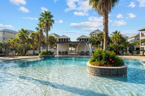 A clear swimming pool with a stone edge, surrounded by palm trees and lounge chairs. - Southern Exposure (Orange Beach)