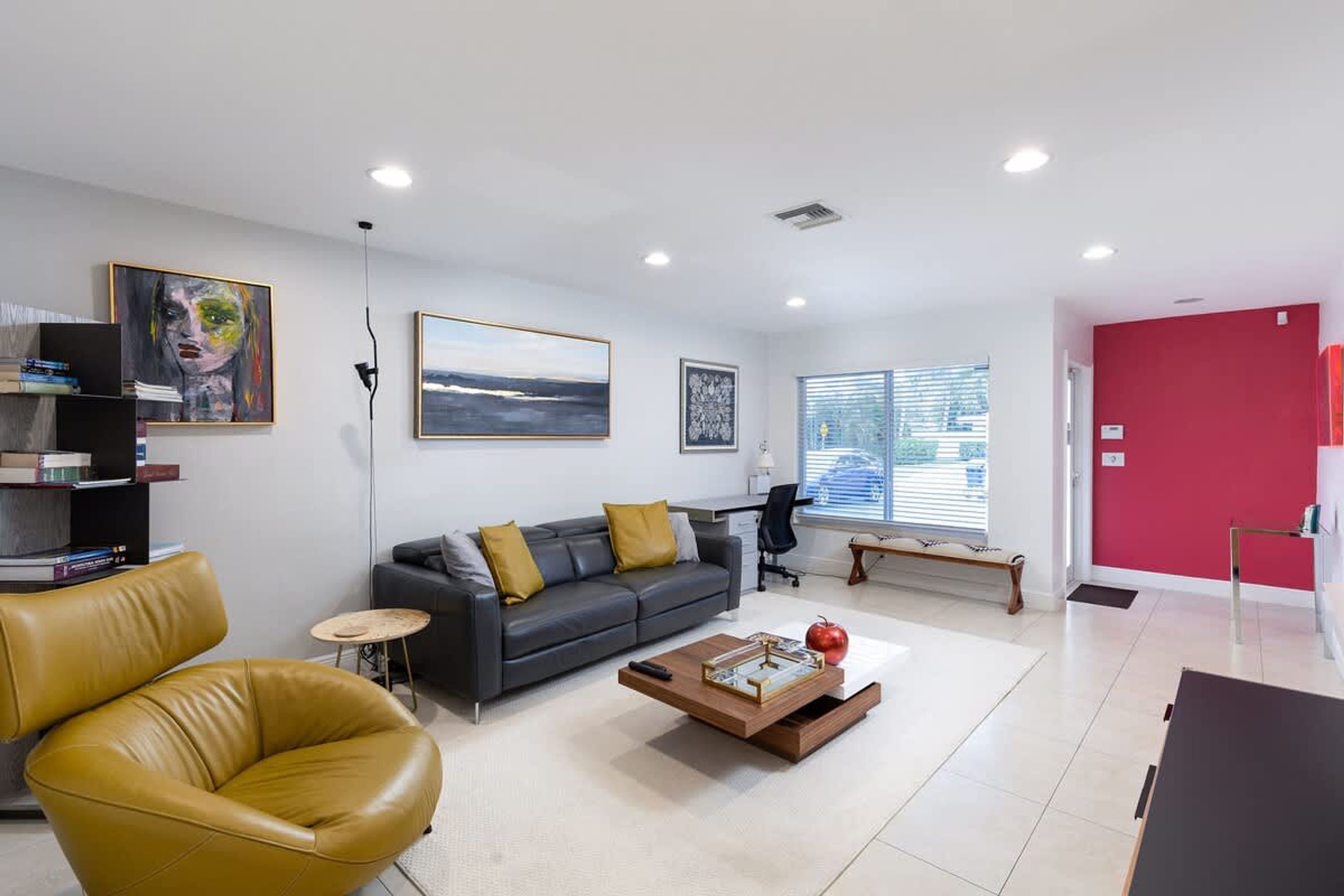 A modern living room with a sofa, coffee table, and a bookshelf.