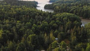 Vue aérienne d’une zone boisée avec un chemin de terre menant à un espace circulaire aménagé en aire de repos.