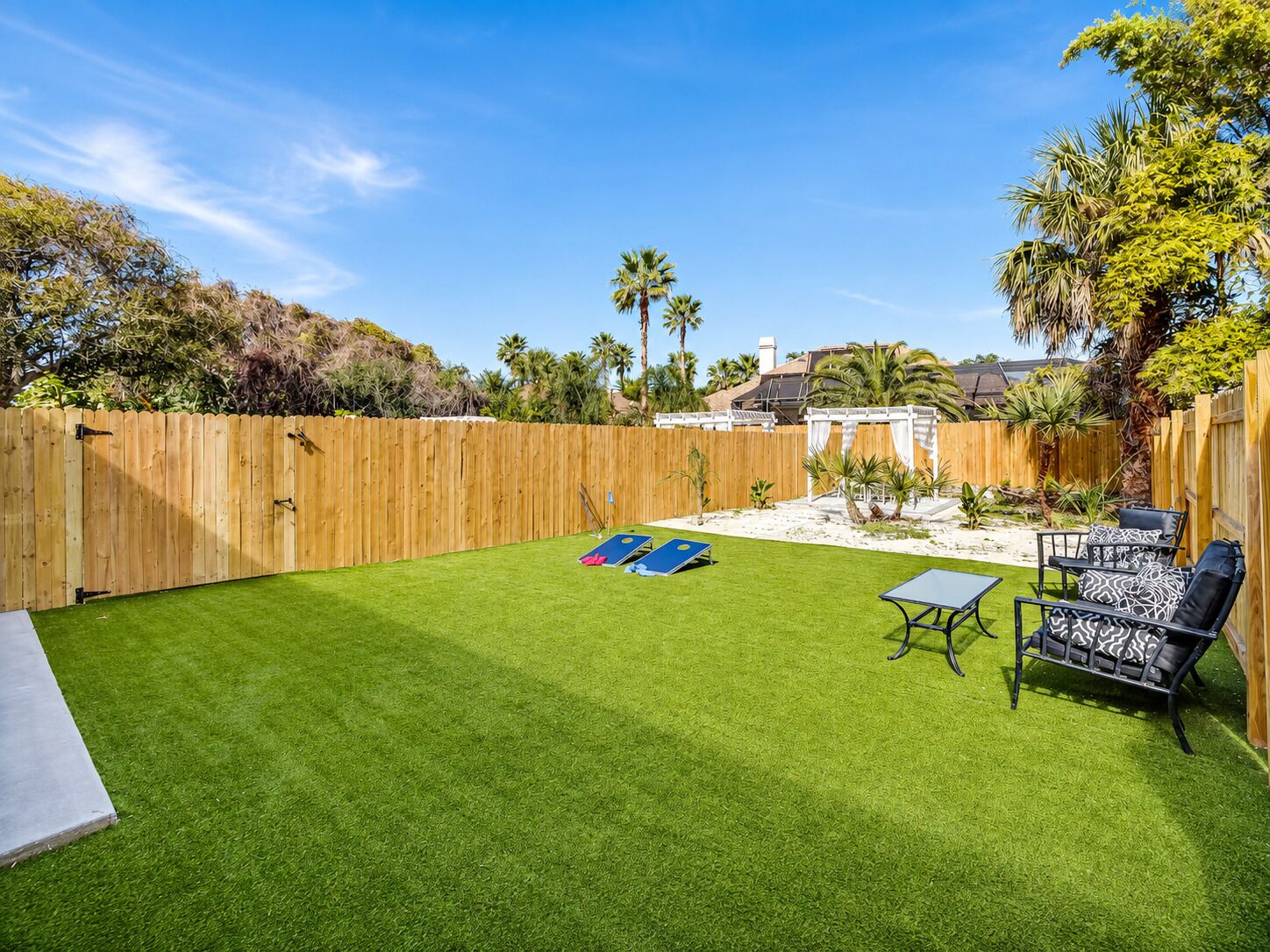 Un jardin avec une pelouse artificielle, une table de billard et du mobilier d’extérieur.